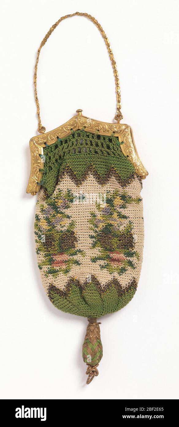 Sac à main. Petit sac à main en soie crochetée et fil d'or en vert, blanc, rouge et jaune pâle dans le motif de grappes de fleurs. Bordure verte des dents de scie en haut et en bas. Placez-vous dans un cadre doré au sommet avec le loquet à fermer. Chaîne en or fin pour le transport. Banque D'Images