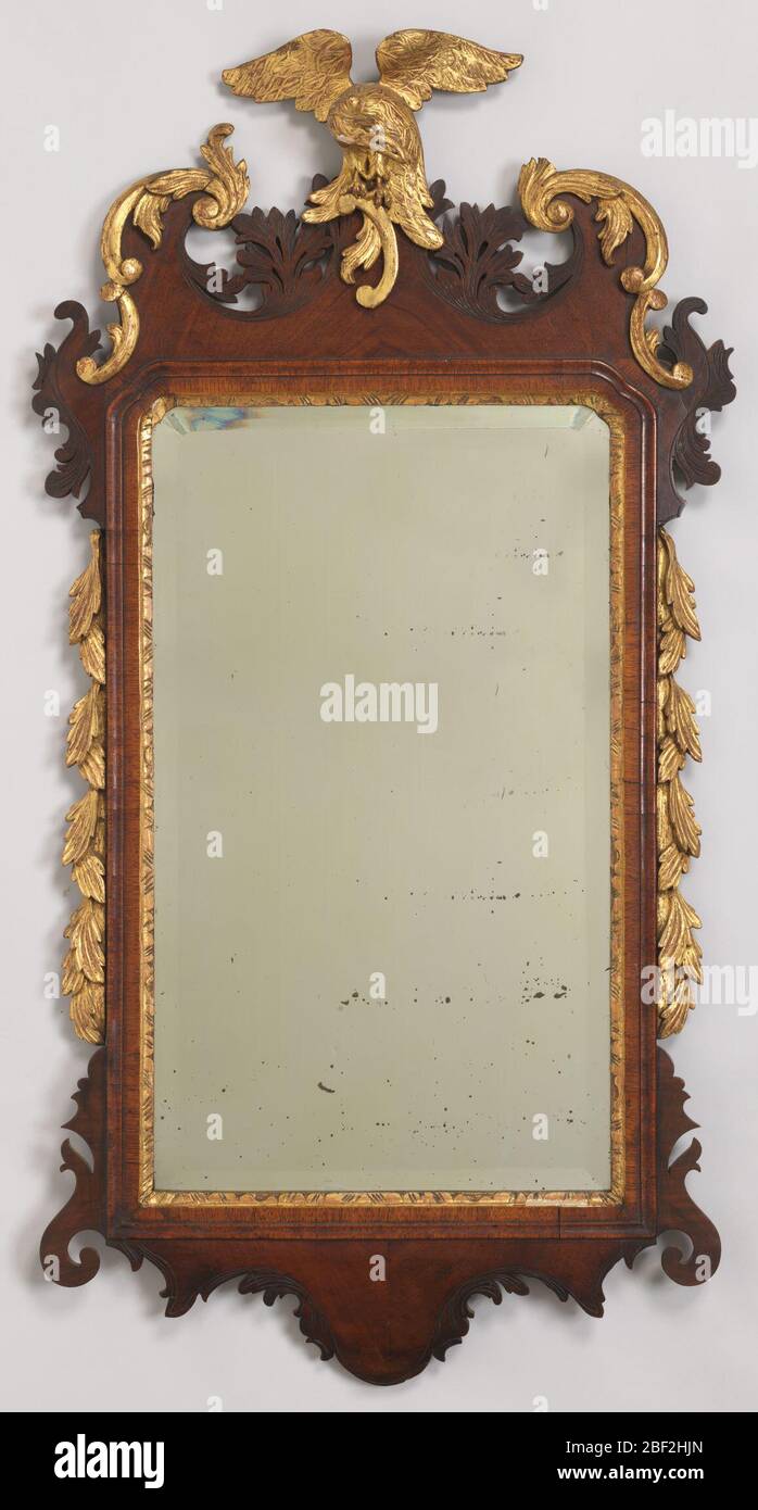 Miroir. Cadre vertical sculpté et doré, double voûte en haut avec grande pyramide centrée de feuillage asymétrique sculpté un jour et de grandes formes de feuilles incurvées à chaque coin qui s'écoulent dans les courbes de serpentine et se rejoignent ensuite sur les côtés droits; fleurs enchevêtrées autour de la dfi droite Banque D'Images
