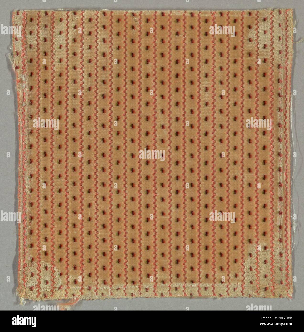 Fragment. Fragment de velours brun clair avec rayures roses verticales et pois de polka tricolores de vert, noir et orange. Banque D'Images