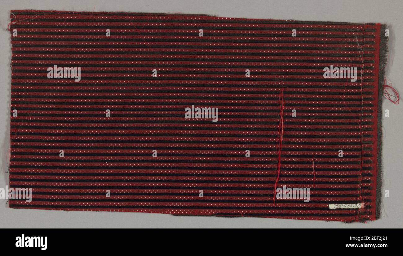 Fragment. Velours représentant un sol rouge avec de minuscules taches de rayures noires horizontales blanches et étroites. Banque D'Images