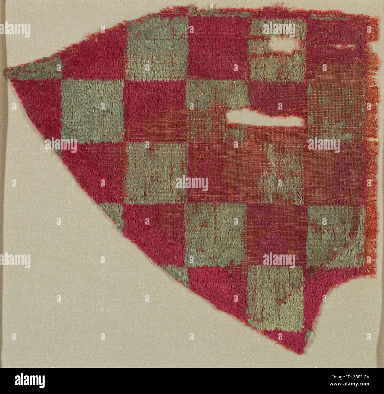 Fragment. Fragmenter dans un motif de damier de carrés rouges et verts délavés. Banque D'Images