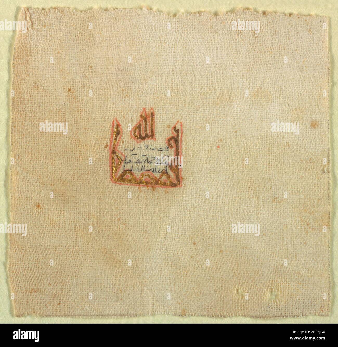 Textile. Petit fragment de tissu Uni avec une marque imprimée en rouge et or. L'inscription dans le fil noir indique 'Lilla' (Dieu). De Fuslat, Egypte. Banque D'Images