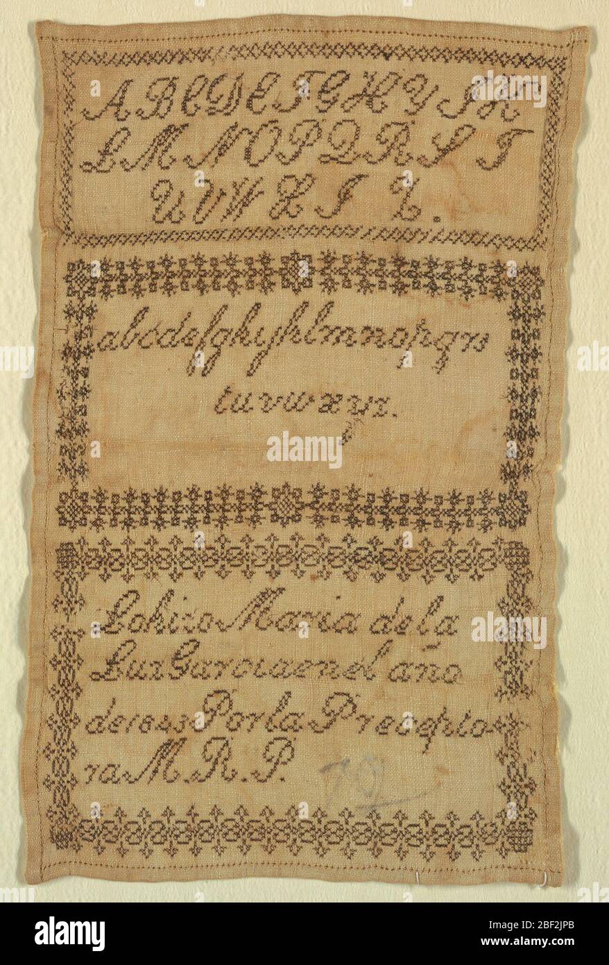 Echantillonneur. Echantillonneur divisé en trois panneaux entourés de bords géométriques. En haut, un alphabet majuscule, au milieu un alphabet minuscule, et au bas de l'inscription, tout en noir sur un sol blanc. Banque D'Images
