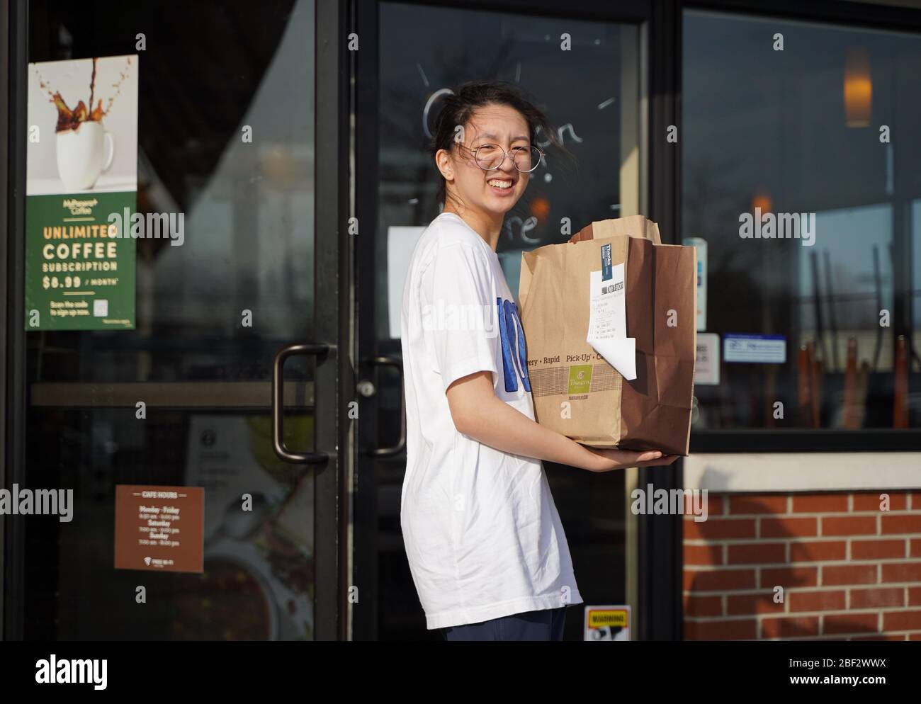 Newington, CT / USA - 19 mars 2020: Asian girl porte un sac plein de nourriture à partir d'un restaurant Panera Banque D'Images