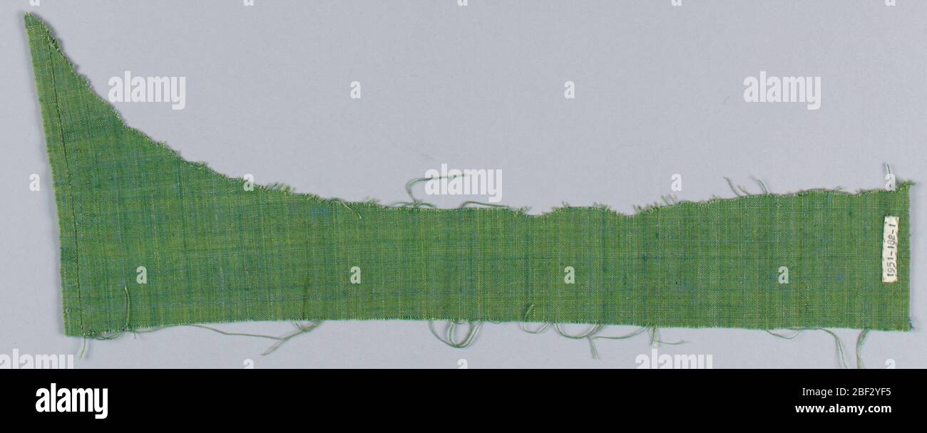 Textile. Petite pièce de tissu fermement tissé dans des tons de vert qui varient de bleu-vert à jaune-vert. Slubs et variations dans l'épaisseur du fil. Banque D'Images