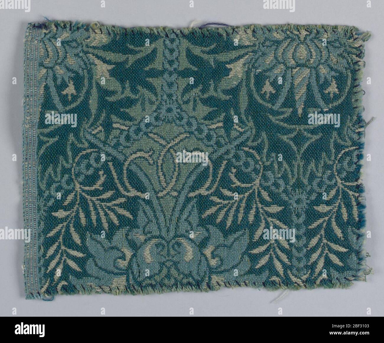 Nid d'abeilles. Design avec un motif symétrique sur toute la surface d'oiseaux confrontés entre les feuilles et les fleurs. Dans les tons de vert et de rose, avec blanc cassé et bleu pâle sur un sol bleu-vert foncé. Banque D'Images