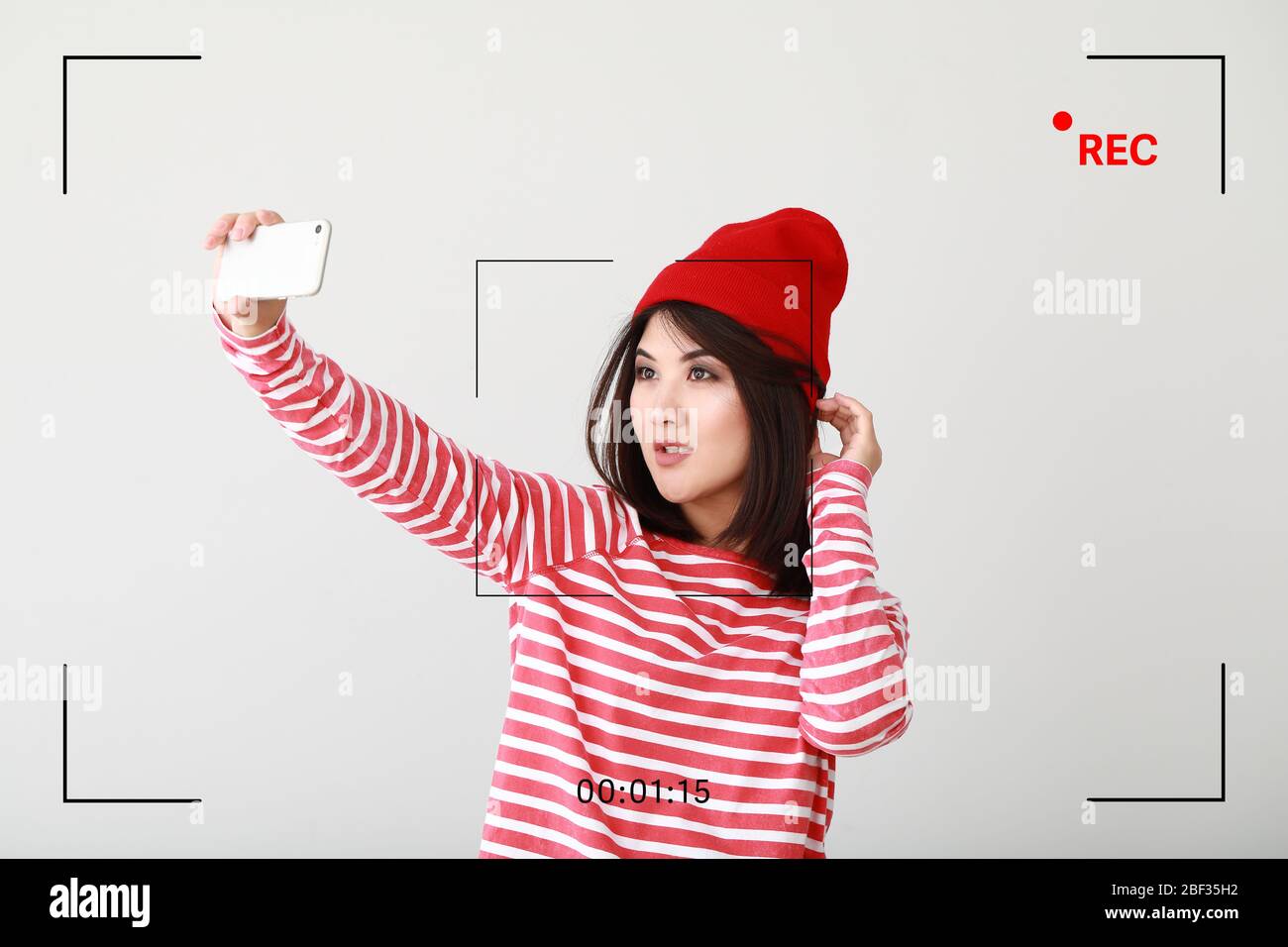 Portrait de beau blogueur asiatique prenant selfie sur fond clair Banque D'Images