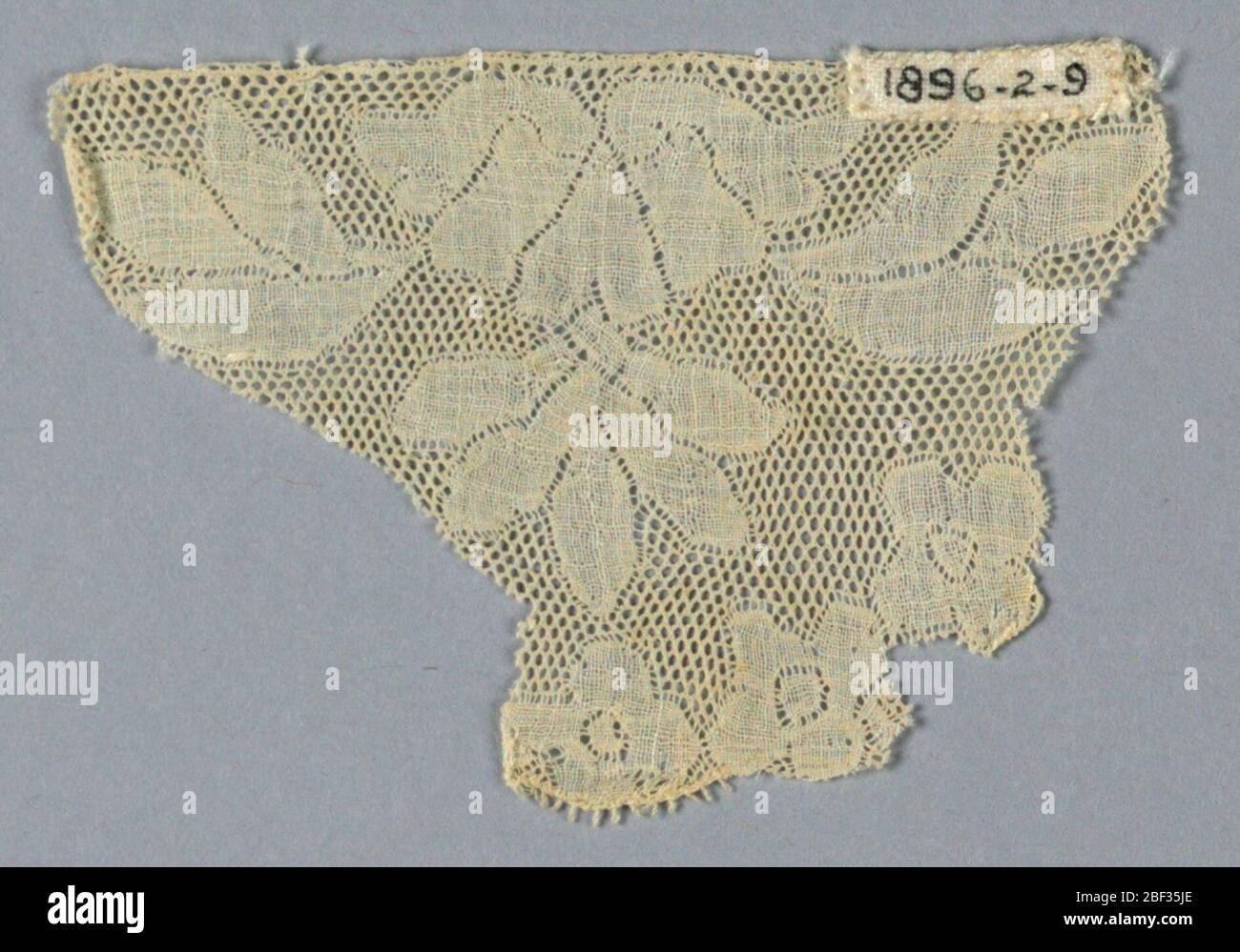 Fragment. Fragment triangulaire avec une conception symétrique de fleurs et de feuillage. Sol de Valenciennes. Banque D'Images