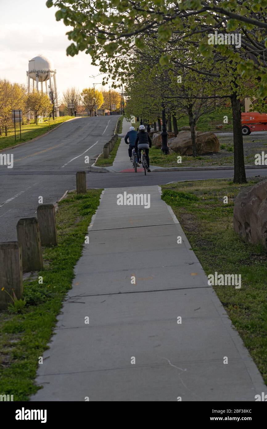 NEW YORK, États-Unis - 15 AVRIL : un couple de faire du vélo dans un parc presque vide de Randall et des îles Wards au milieu de l'avant-frein du coronavirus (COVID-19) le 15 avril, Banque D'Images