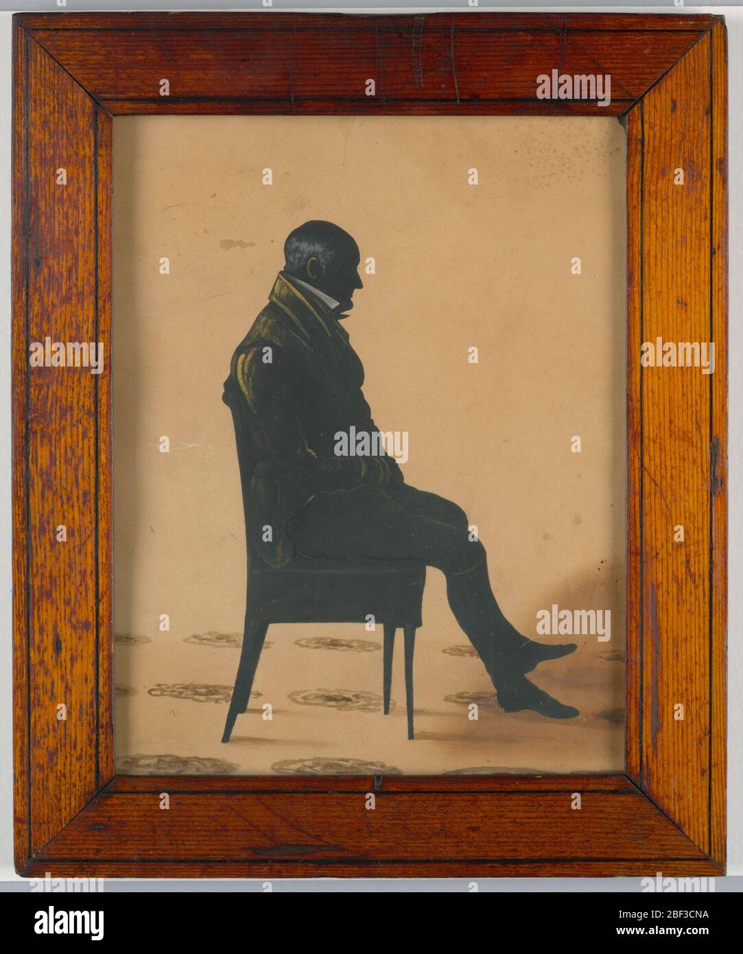 Silhouette. Silhouette pleine longueur d'un homme en chaise, face à droite. Cadre en bois. Banque D'Images