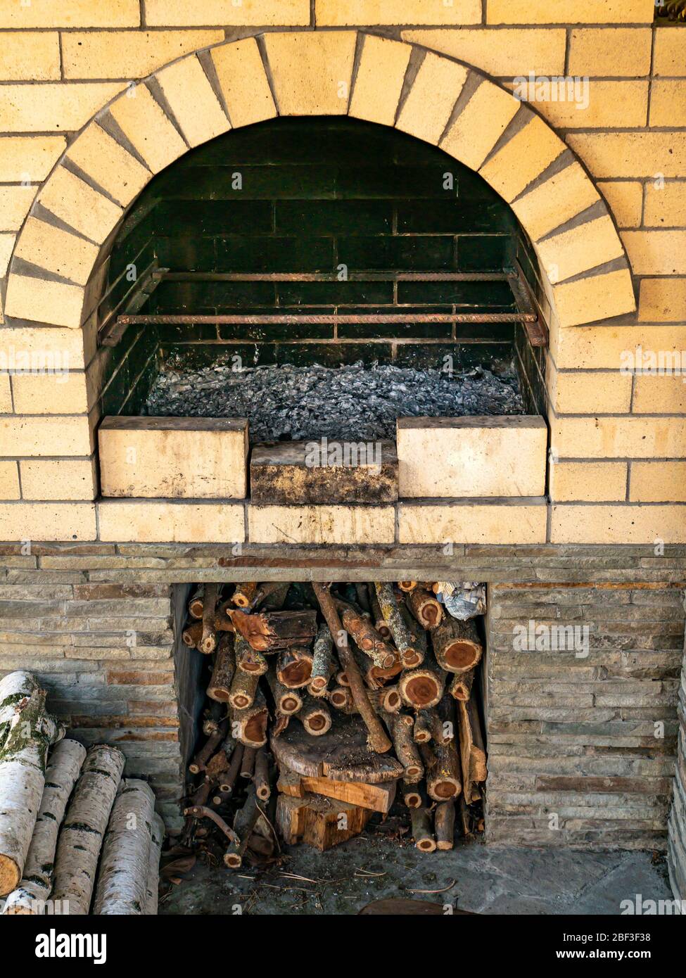 Poêle en bois de brique avec bois de chauffage dans la rue. Banque D'Images