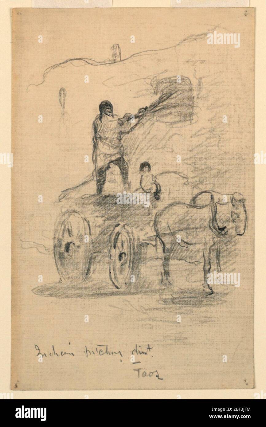 Taos, pichet indien. Un chiffre se trouve dans un chariot à quatre roues tiré par un cheval et en pelle la saleté. Bâtiments présentés derrière. Banque D'Images