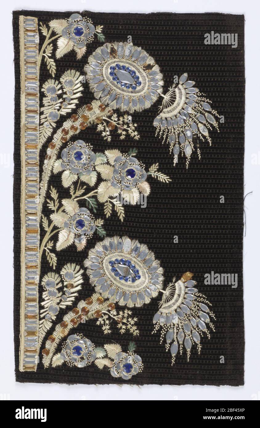 Échantillon de broderie. Motif fleuri brodé avec soie multicolore et perles de verre bleu, argent et or sur un velours cisele noir à motifs. Banque D'Images