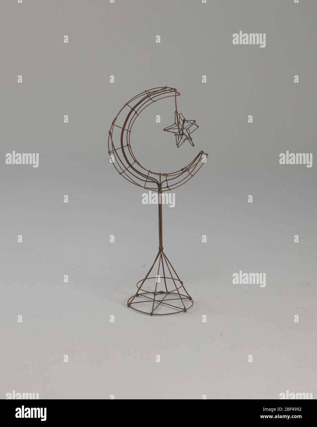 Étoile de croissant de châssis métallique sur le statif. En pleurant le symbolisme, les symboles du repos et de la paix sont devenus des options populaires et consolation. Un motif de fleurs populaire pour les funérailles qui ont fait allusion au repos était l'étoile et le Croissant. L'étoile, lorsqu'elle était avec le croissant, était symbolique du sommeil d'une âme pure et innocente. Banque D'Images
