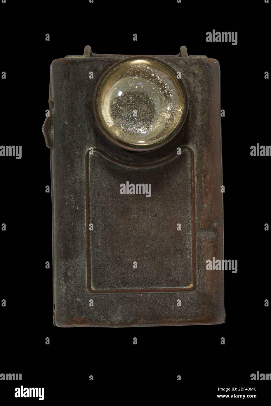 Lampe de poche à ceinture militaire. Lampe de poche avec corps en métal, lentille en verre et sangle en cuir pour fixer la lumière à une ceinture. L'avant de la lampe de poche est doté d'une ampoule circulaire en verre. À l'arrière, une sangle en cuir est fixée avec un support métallique vissé sur le corps principal des deux côtés. Banque D'Images