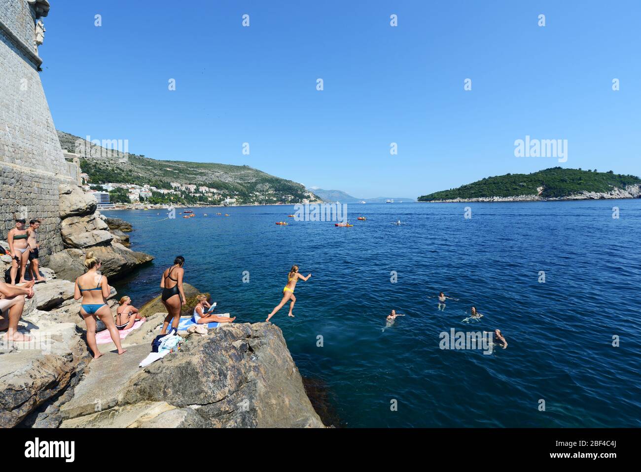 Le saut - saut dans la mer Adriatique des falaises sous les murs de la vieille ville de Dubrovnik, Croatie. Banque D'Images