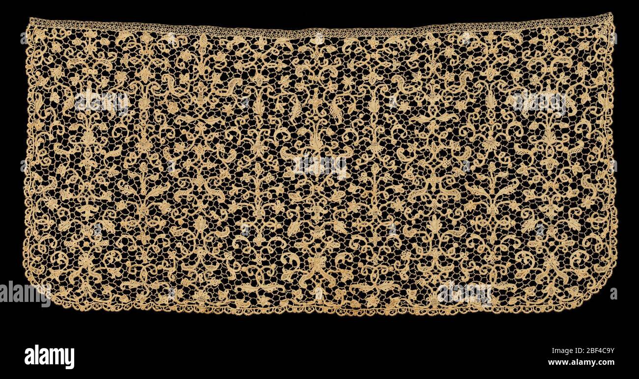 Cravat end Cravat end montrant un dessin de fleurs et de feuilles défilant de formes arrangées dans un modèle de candelabra. Bordure sur trois avec des pétoncles étroits de dentelle à aiguille. Banque D'Images