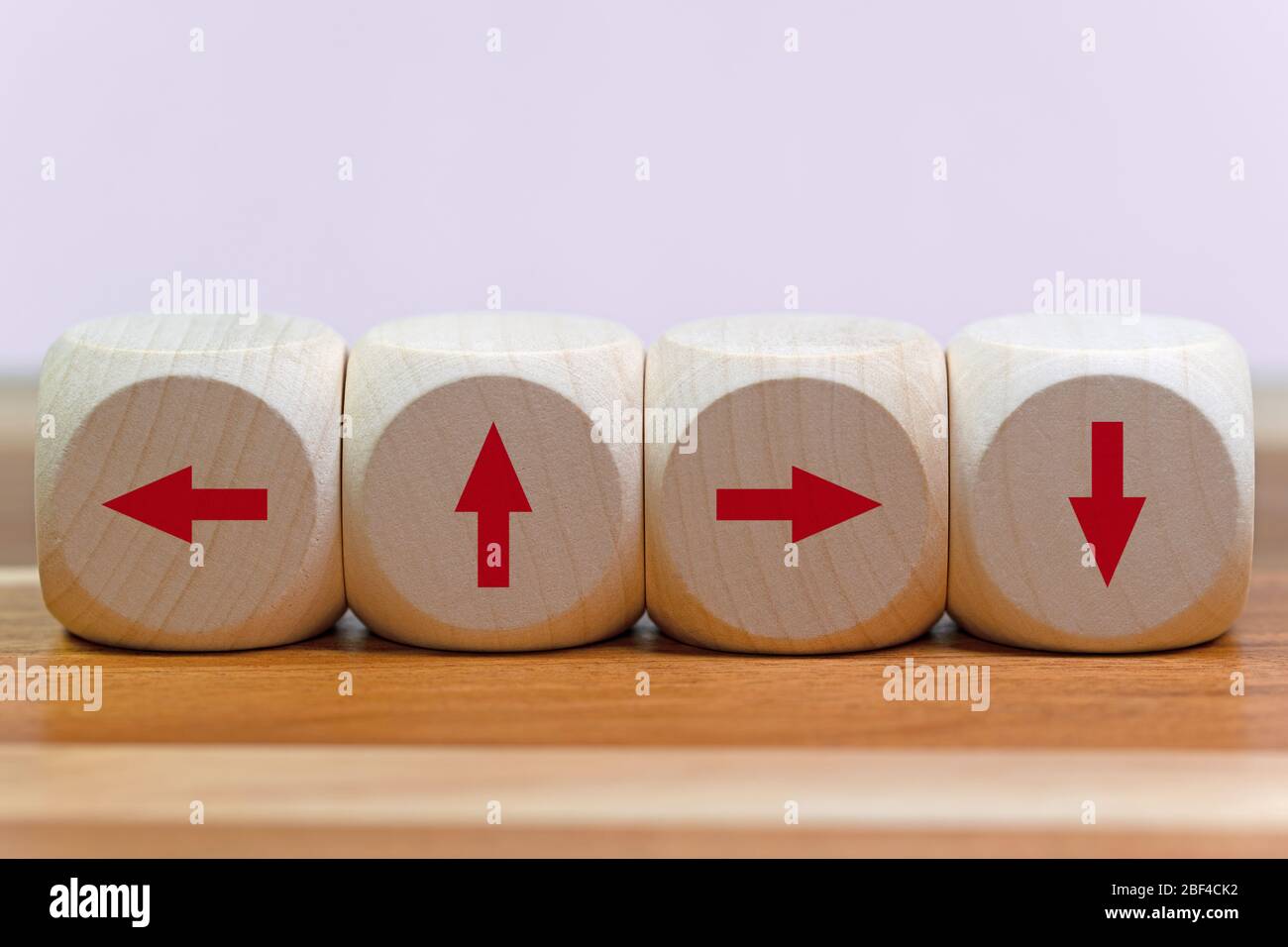 Quatre cubes en bois avec flèches dans toutes les directions Banque D'Images