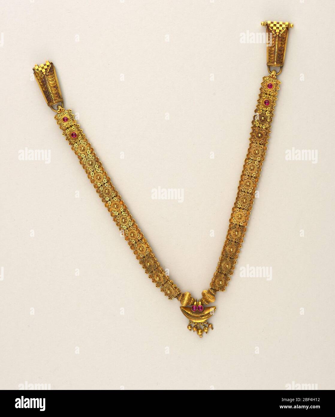 Collier. Perles d'or, motifs délicats de filree sur la surface supérieure, six montés avec des rubis de calochon, et sous la surface de chaque perle composée d'éléments dorés angulaires, polygonaux. Banque D'Images