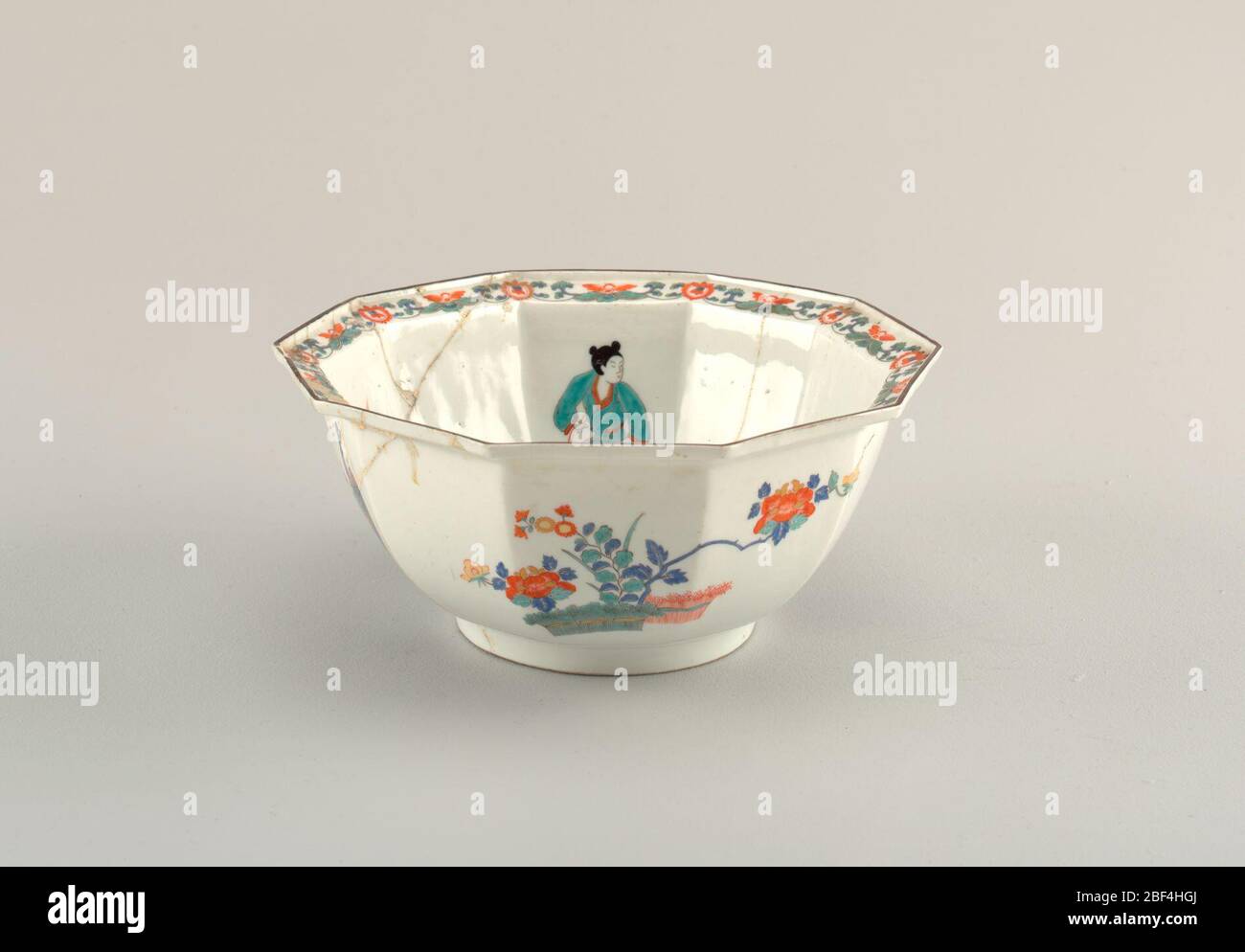 Bol octogonal de la collection du Palais japonais. Octogonal. Profond, sur pied cylindrique simple ; bord tourné vers l'extérieur, avec bord vertical étroit. Décoré de fleurs, de figurines et de chiens, dans un style coréen. Banque D'Images