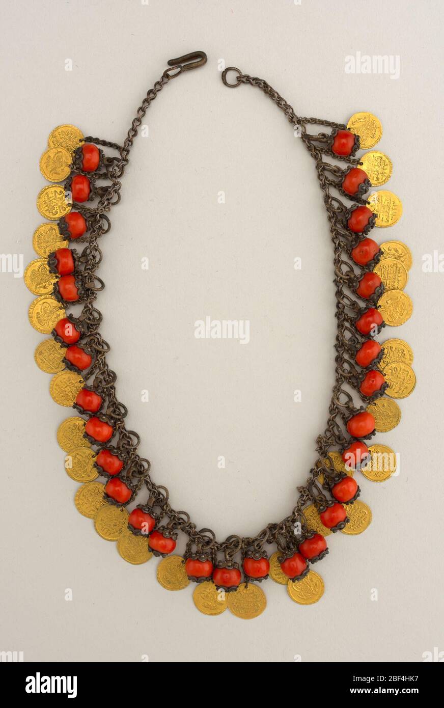 Collier. Chaîne argent avec pendentifs de corail en filigree argent alternant avec disques or. Banque D'Images