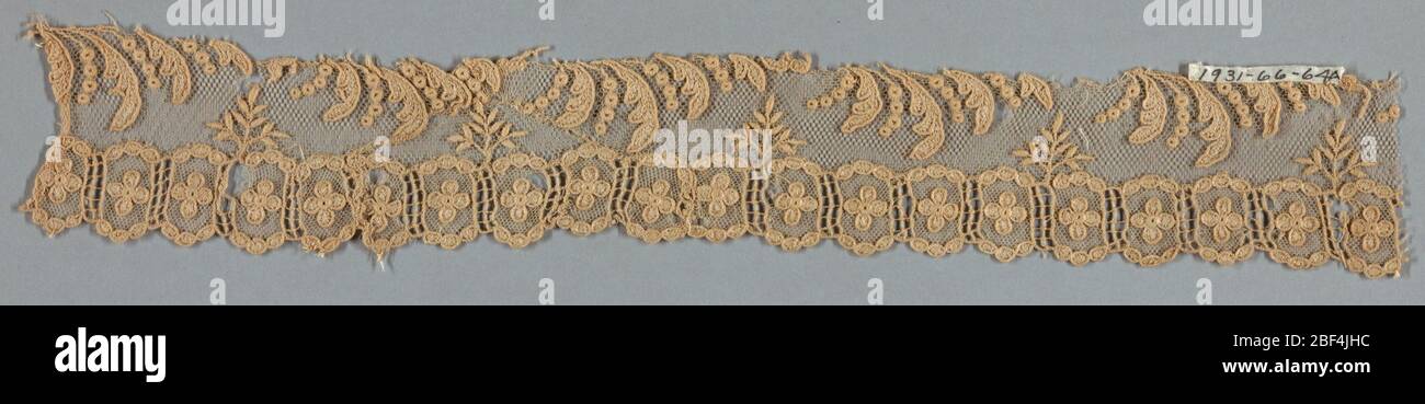 Fragment. Imitation beige Alençon. Bande ornementale constituée de petits morceaux de dentelle, pour le centre une tige avec des feuilles avec une bordure de chaque côté dans le dessin de quatre pétales de fleurs dans les compartiments. Banque D'Images