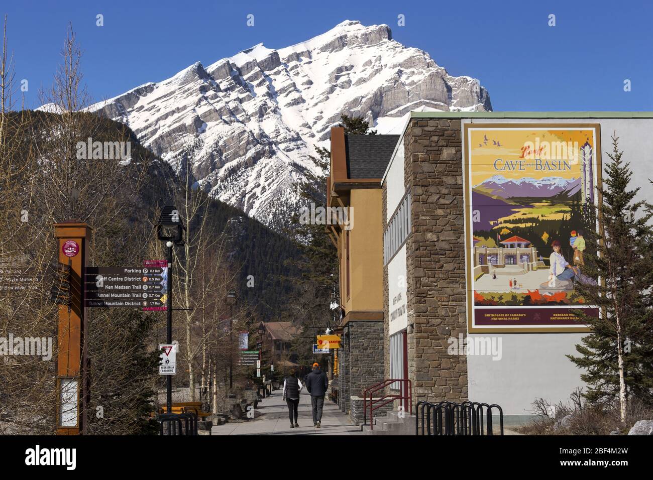 Touristes gens marchant à Banff par Urban City Street Sign. Paysage du pic de montagne des Cascades enneigées. Horizon du parc national des Rocheuses canadiennes de l'Alberta Banque D'Images