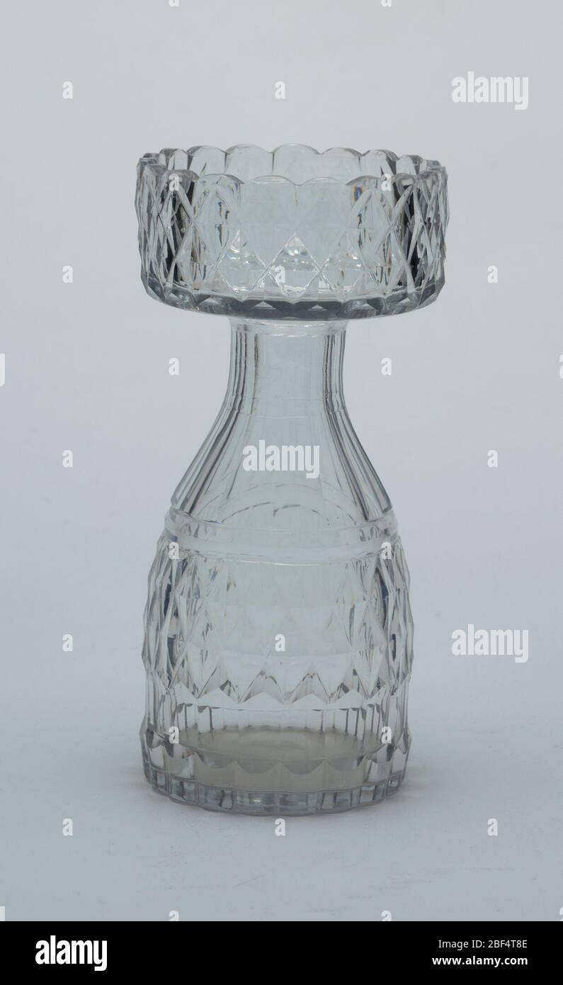 Vase. Le corps ovoïde s'effile sur le col cannelé, la large lèvre plate avec bord retourné et bordure festonnée ; le corps et la jante supérieure sont coupés avec des diamants, des cannelures de montant à la base. Jacinthe Banque D'Images