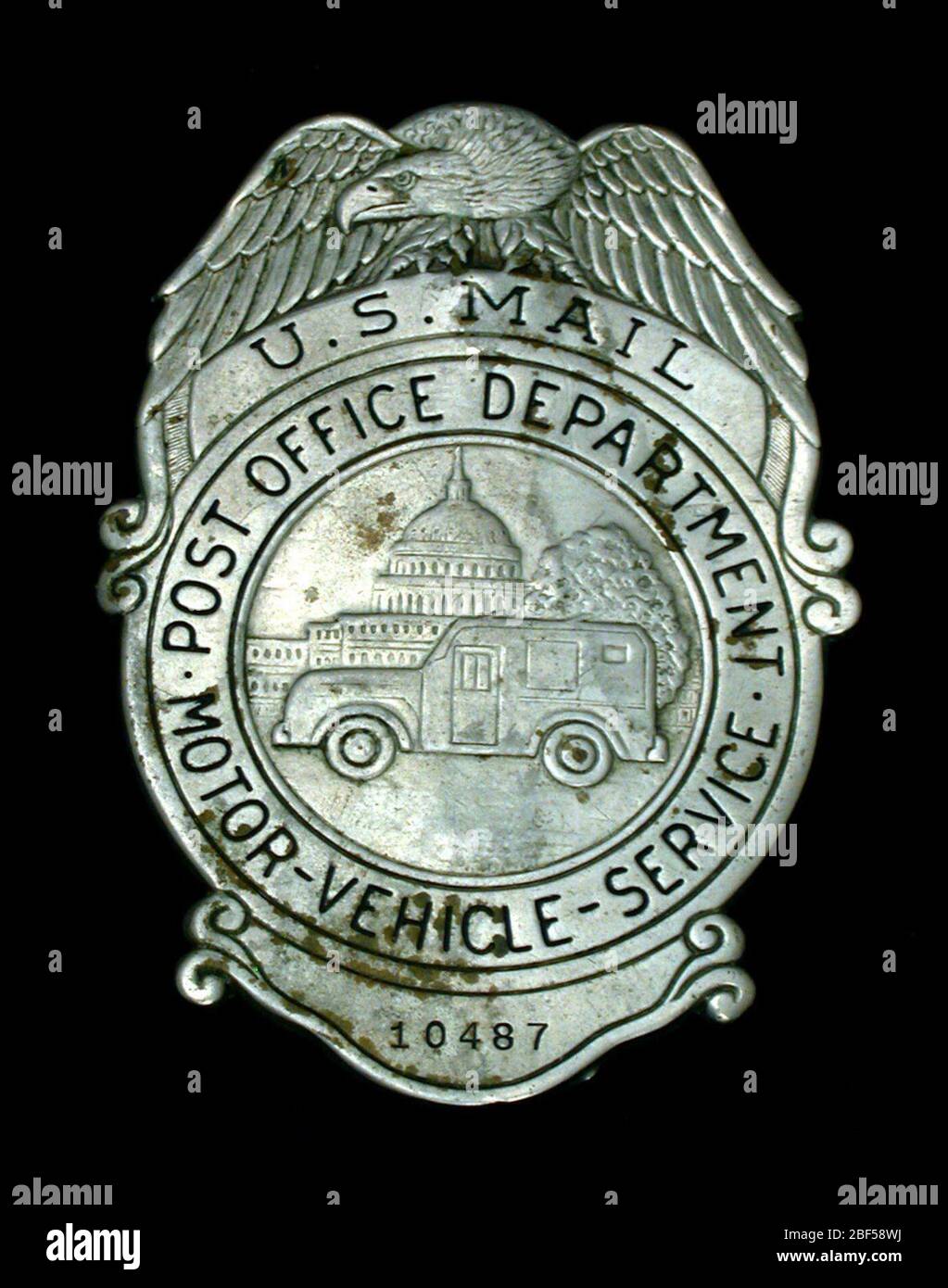 Badge poitrine employé MVS numéro 10487. Badge de sécurité MVS (Service automobile) du département américain des postes, numéro 10487, avec goupille verticale à charnière et attache de sécurité sur le verso. L'aigle étalé surmonte un médaillon circulaire avec la partie supérieure marquée 'U.S. MAIL'. Médaillon ours U. S. Banque D'Images