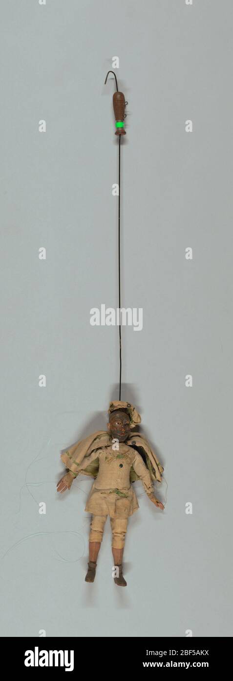 Breughella. Ensemble de marionnettes Commedia dell'arte, chacune avec masques faciaux et costumes de caractère. Breughella montré avec masque barbu. Tenue blanche, cape et casquette garnie de vert. Bottes courtes marron. Mains en bois cousues dans les manchons. Banque D'Images