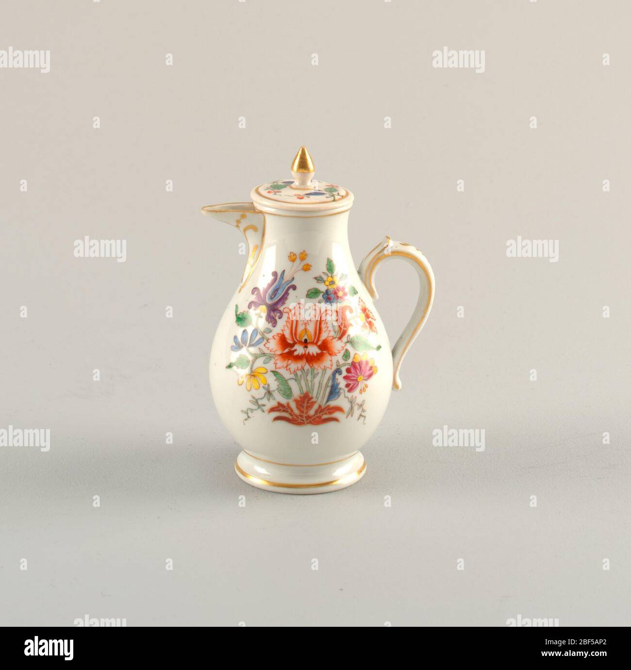 Réservoir de lait et couvercle. Forme de poire tronquée décorée avec des compositions multicolores de fleurs stylisées et de feuillage. Avec décoration en or sur la poignée, bec, pied, couvercle et finale. Banque D'Images