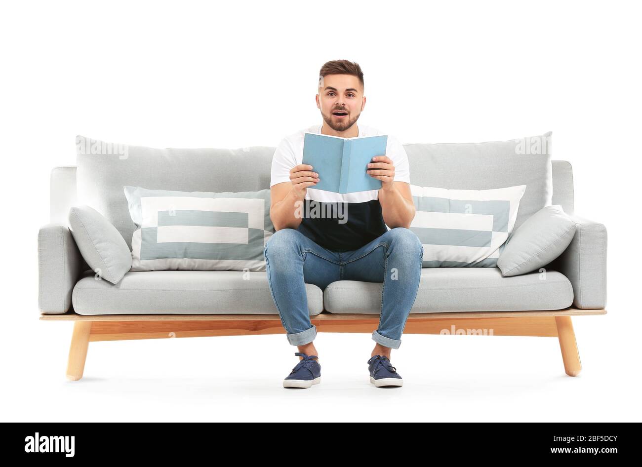 Livre de lecture pour jeune homme assis sur un canapé sur fond blanc Photo  Stock - Alamy