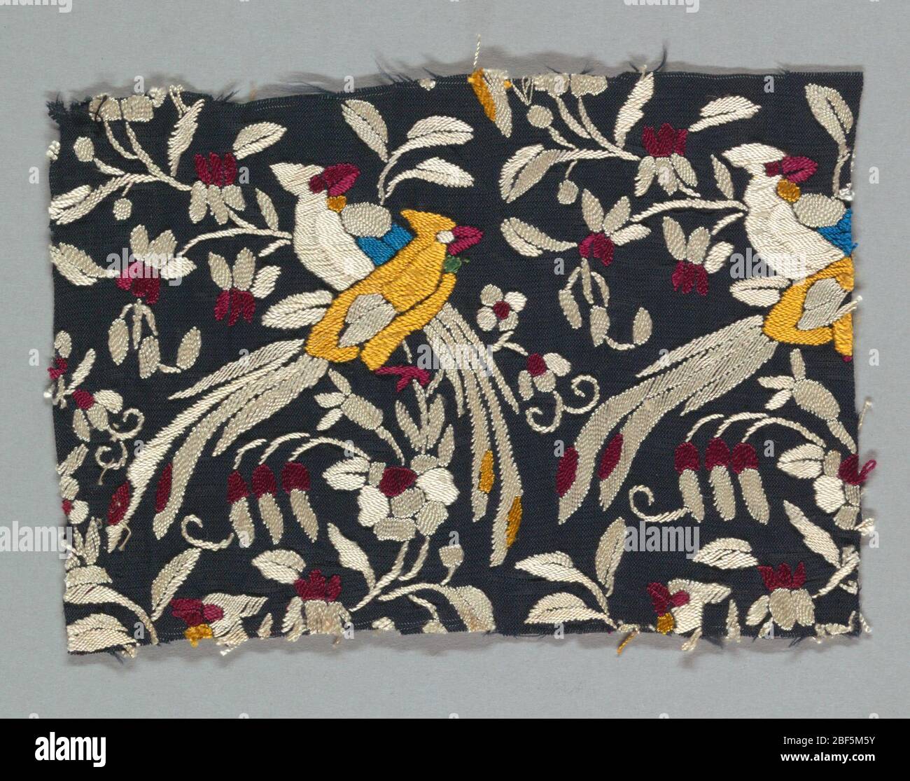 Fragment. Carré en soie noire à onglet ouvert brodé, principalement en satin, en soie blanche, rouge et jaune. Motif fleurs et oiseaux. Banque D'Images