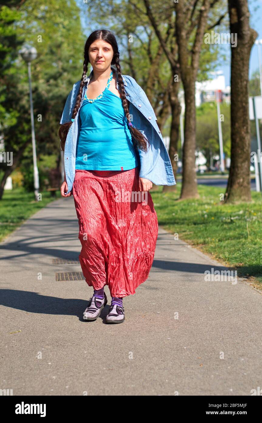 Jeune femme hipster marchant dans la rue de banlieue Banque D'Images