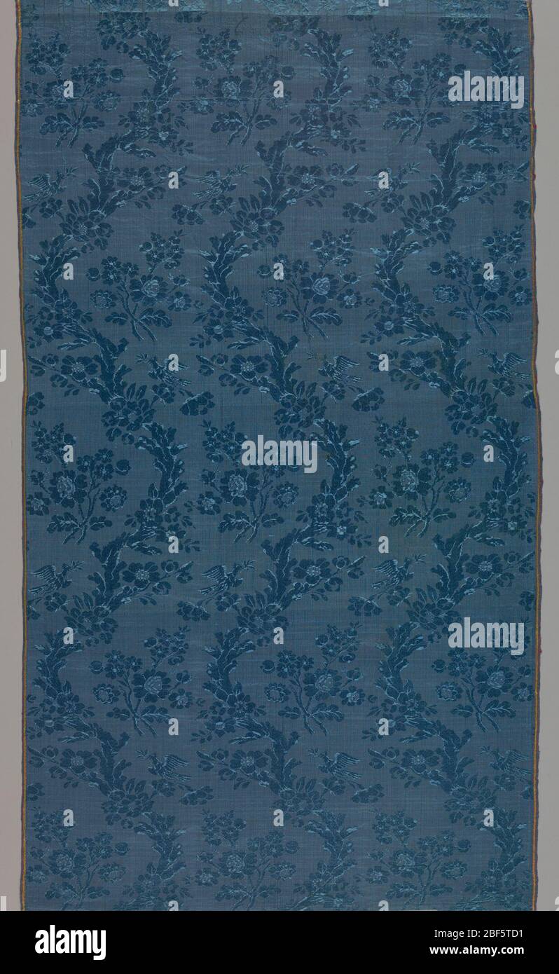 Textile. Motif bleu-bleu continu de trois vignes fleuries naturalistes à bordures fleuries avec un oiseau perché sur une fleur placée côte à côte. Branches de fleurs nichées sur chaque courbe des vignes. Banque D'Images