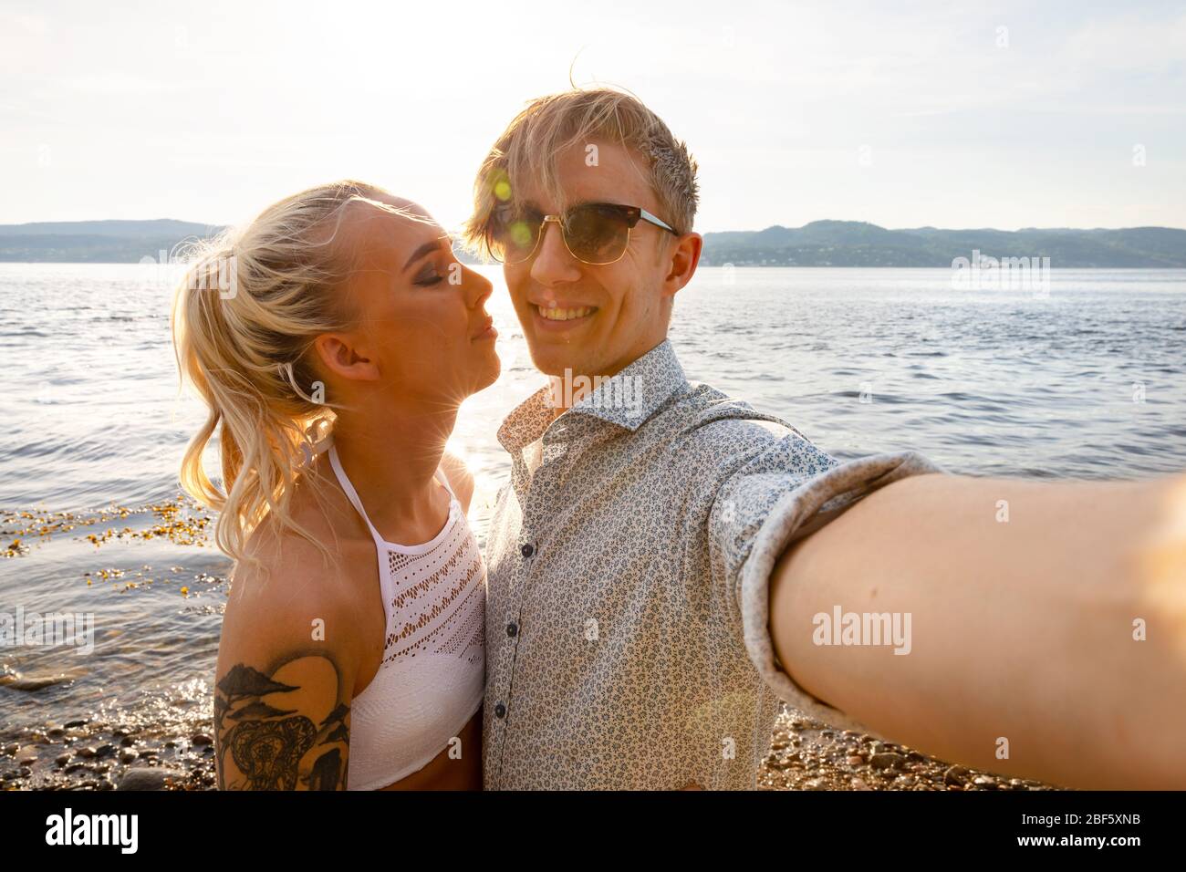 Joyeux jeune homme prenant Selfie avec une petite amie à Beach Banque D'Images