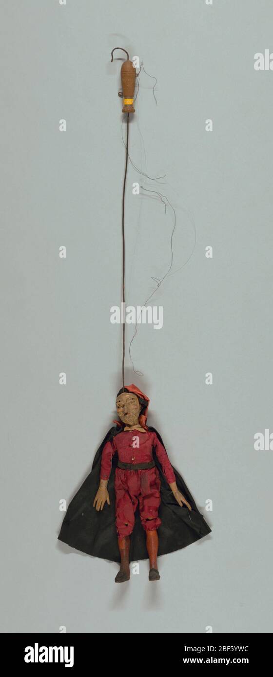 Pantalone. Ensemble de marionnettes Commedia dell'arte, chacune avec masques faciaux et costumes de caractère. Pantalone montré avec masque barbu et nez accroché. Vêtements et casquette rouges, cape noire. Mains en bois cousues dans les manchons. Banque D'Images