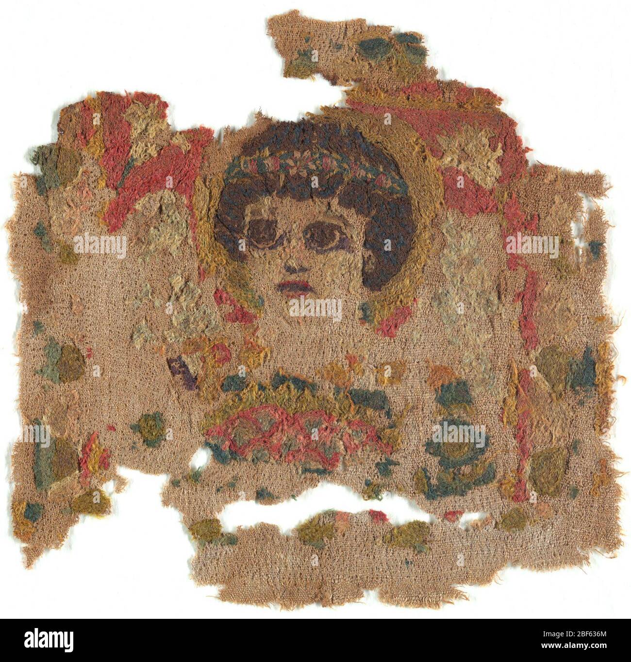 Fragment. Buste d'une figure féminine avec des cheveux sombres et de grands yeux sombres, une couronne de laurier sur la tête, un halo, et des ailes, avec un panier de fleurs tenu sous son menton. Un seul remplissage en lys remplit le coin au-dessus de chaque aile. Banque D'Images