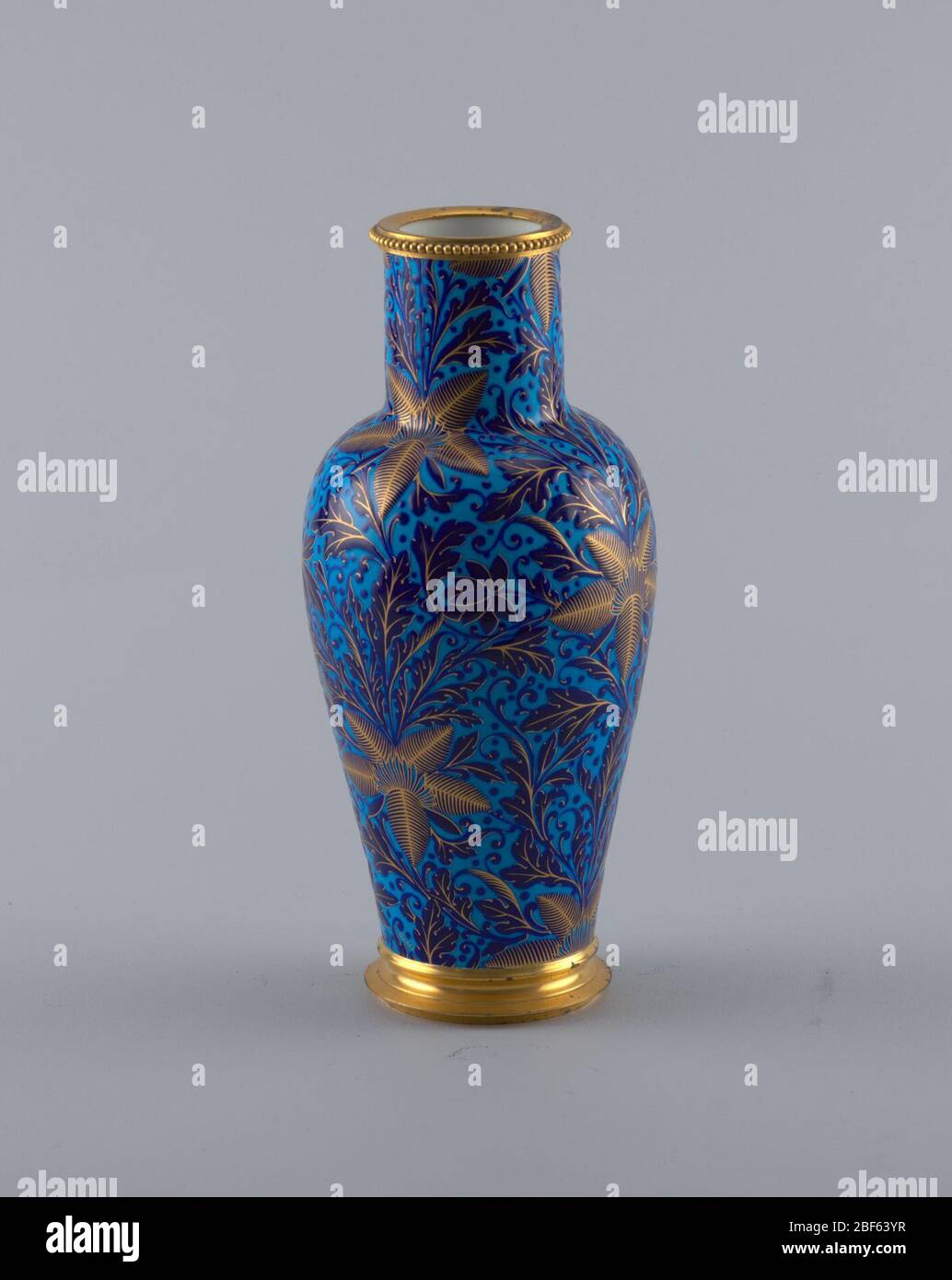 Chinois Ly. Vase en porcelaine bleue avec détails dorés. Vase est décoré avec un motif de grandes feuilles sous forme d'étoiles. Le pied empilé et la lèvre ornée de perles sont tous deux finis en or. Banque D'Images
