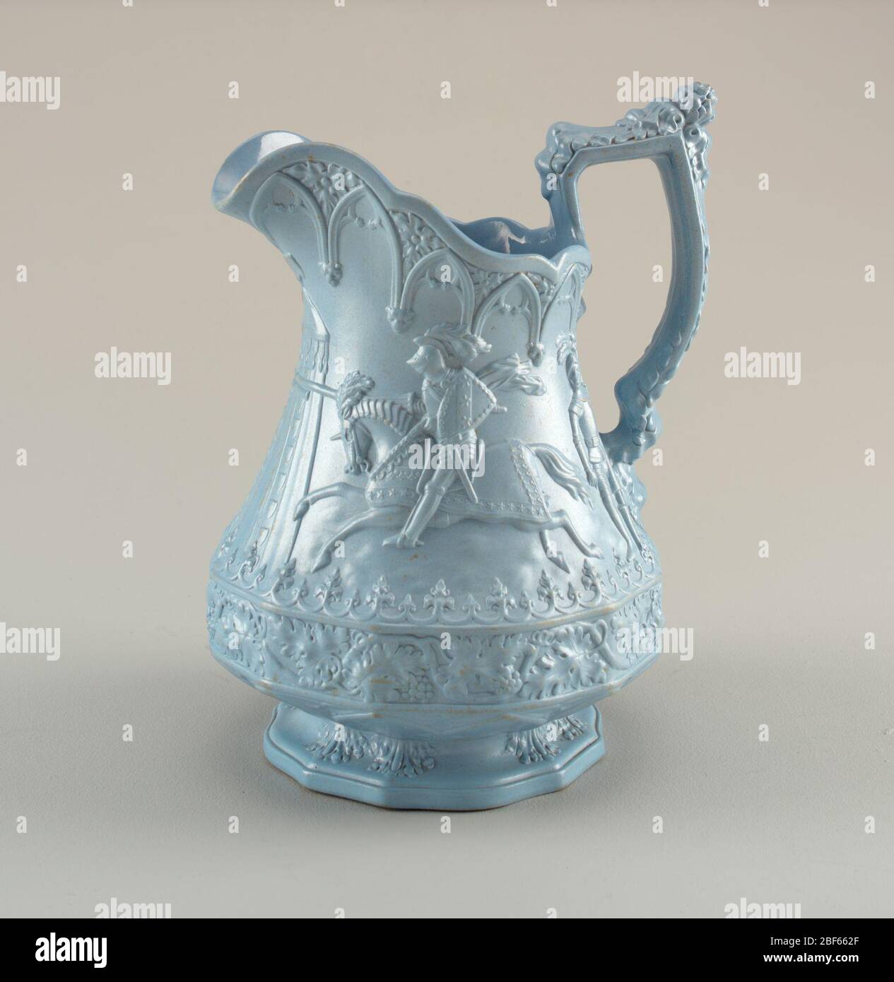 Verseuse. Une verseuse bleue très décorative avec des détails sur le corps, le bec et la poignée. Le centre dépeint un chevalier à cheval dans une scène extérieure. Banque D'Images