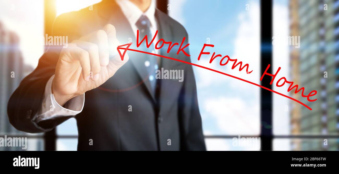 concept « travailler à domicile ». les professionnels qui tiennent un marqueur rouge écrit un mot « travail » à partir de leur domicile sur un écran blanc transparent virtuel Banque D'Images