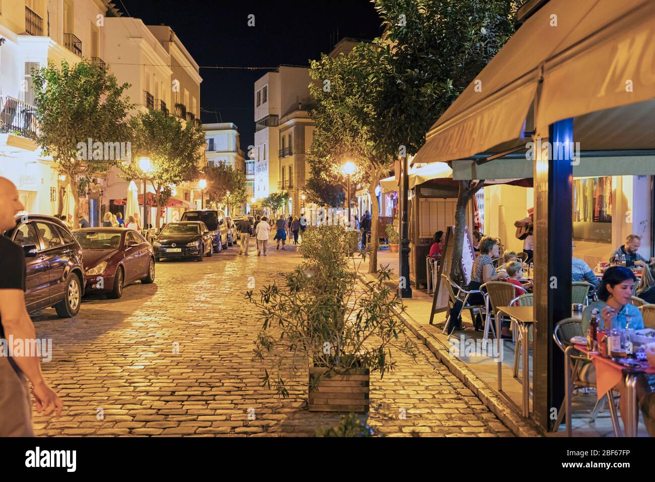 Scène de rue la nuit. Les gens qui dînont dans les restaurants sur le trottoir. Tarifa, Costa de la Luz, province de Cadix, Andalousie, sud de l'Espagne. Banque D'Images