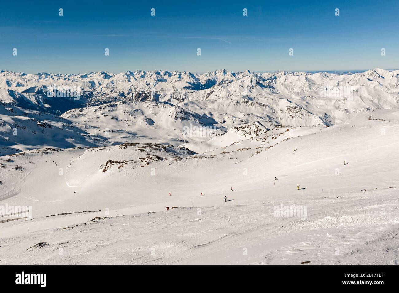 Vue sur une piste de sport d'hiver alpine avec des skieurs en montagne dans la station de ski Banque D'Images