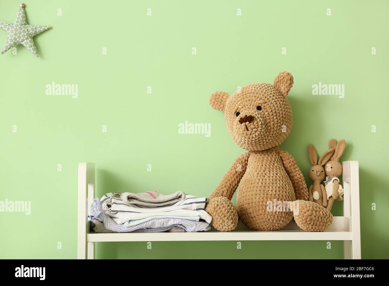 Jouets doués avec vêtements pour bébé sur table dans la chambre des enfants Banque D'Images