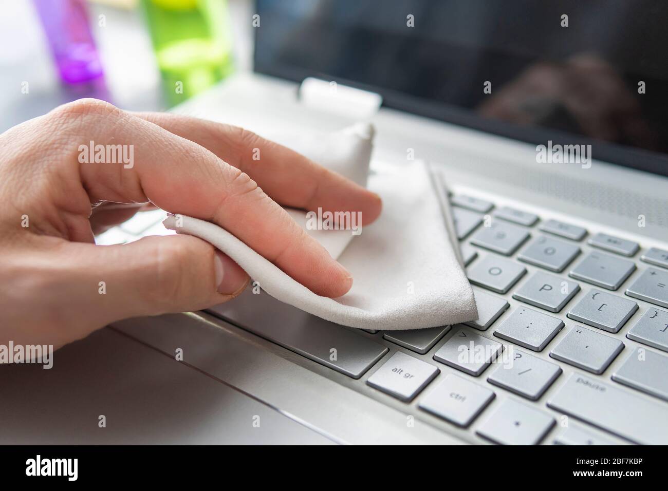 Le clavier est nettoyé. La main d'un homme avec un chiffon blanc nettoie le clavier. Mesures de désinfection pour protéger contre le coronavirus ou tout autre microbe Banque D'Images