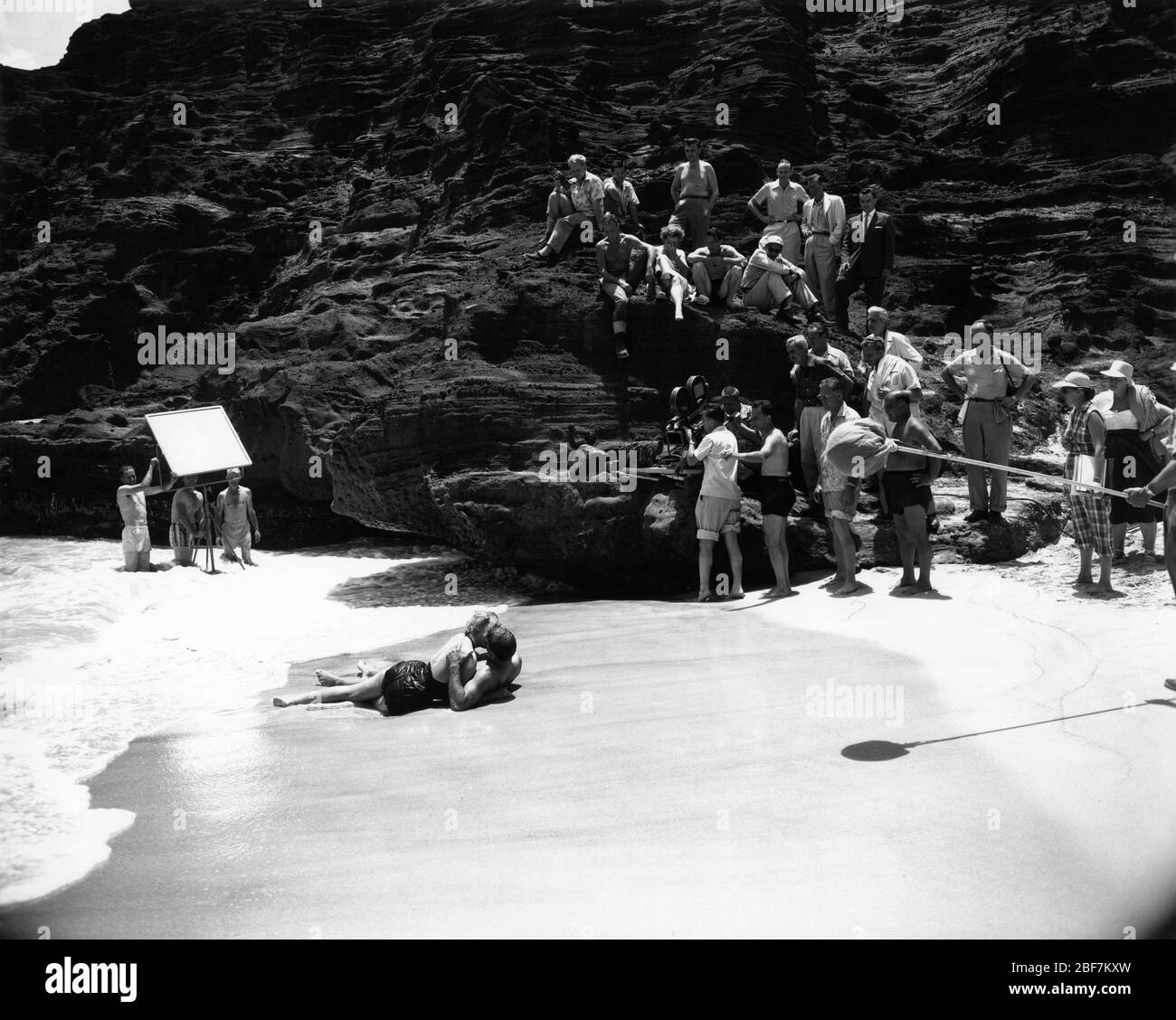 BURT LANCASTER et DEBORAH KERR avec Movie Crew sur place Candid à Halona Cove , O'ahu Hawaii filmant la célèbre scène d'amour de plage pour D'ICI À L'ÉTERNITÉ 1953 réalisateur FRED ZINNEMANN roman James Jones scénario Daniel Taradash Columbia Photos Banque D'Images