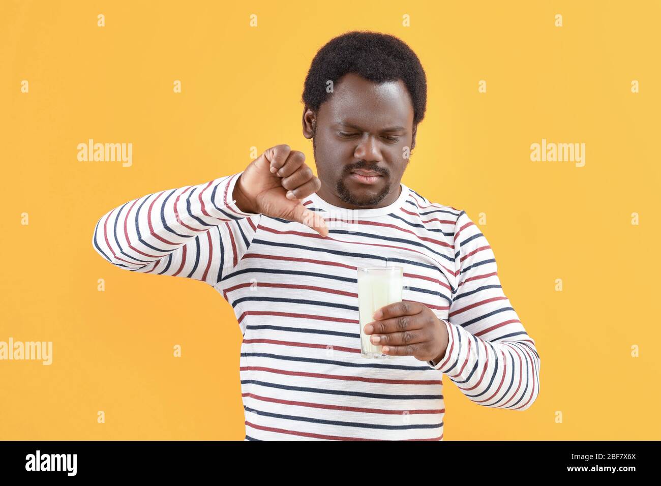 Jeune homme afro-américain souffrant d'allergie aux produits laitiers sur fond de couleur Banque D'Images