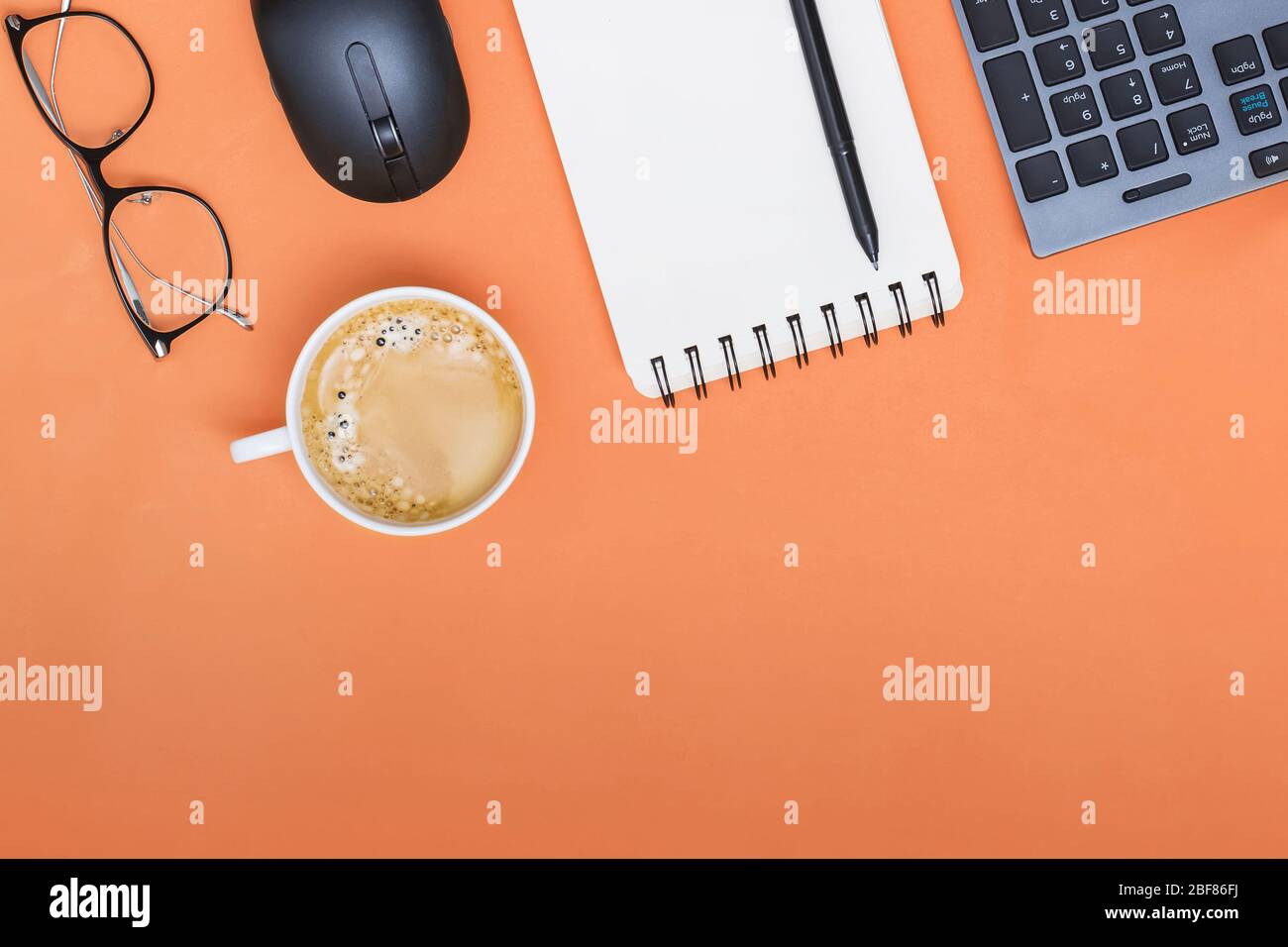 Bureau de Dellow avec ordinateur portable, souris et autres fournitures de travail avec tasse de café. Banque D'Images