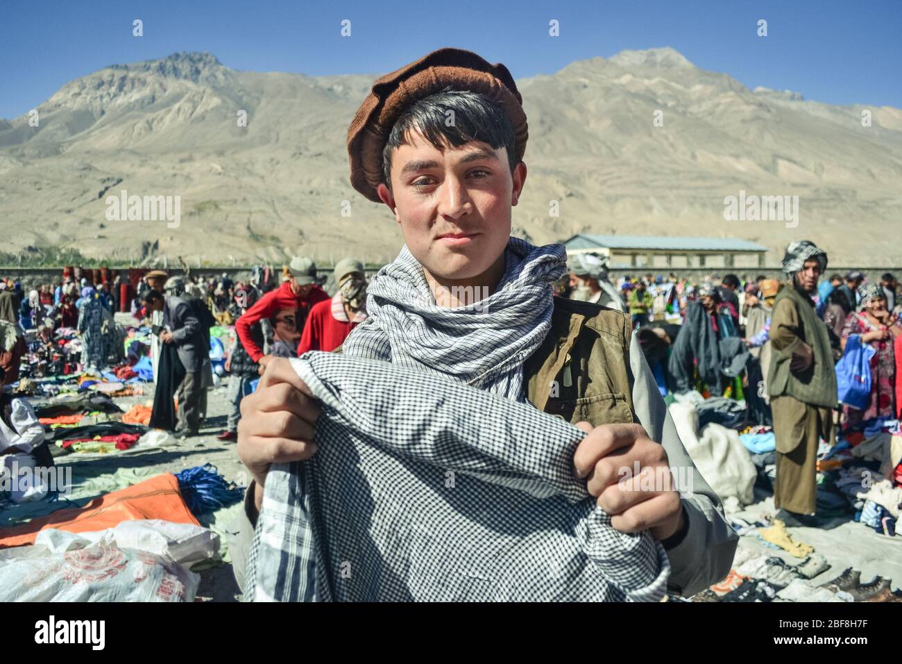 Ischkashim / Afghanistan - 5 octobre 2013: Beau Pachtoun afghan jeune homme  sourie tenant le foulard sur le marché afghan entre le Tadjikistan et l' Afghanistan Photo Stock - Alamy