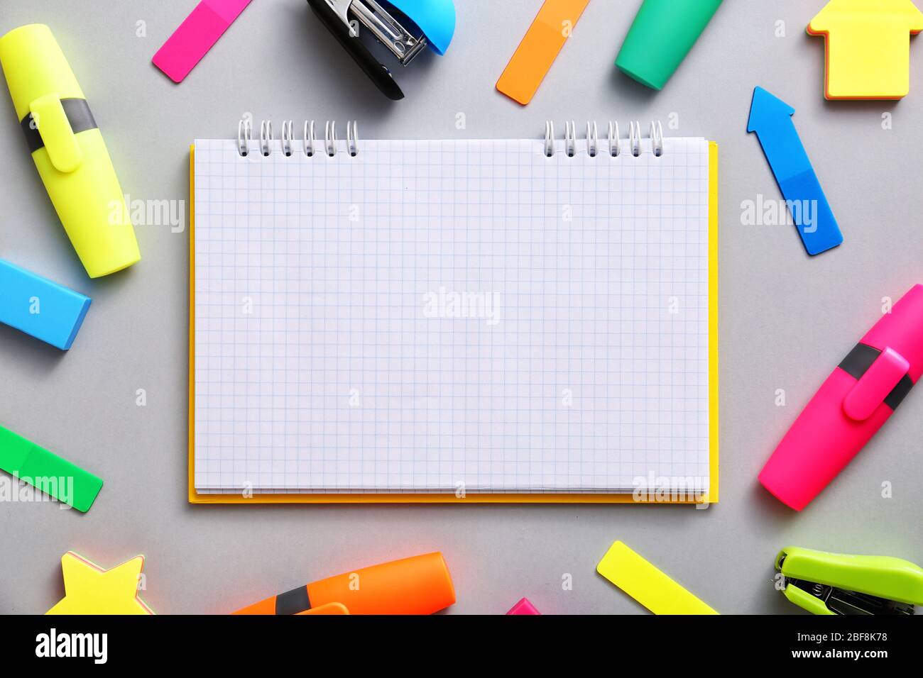 Ordinateur portable avec fournitures scolaires sur fond gris Banque D'Images